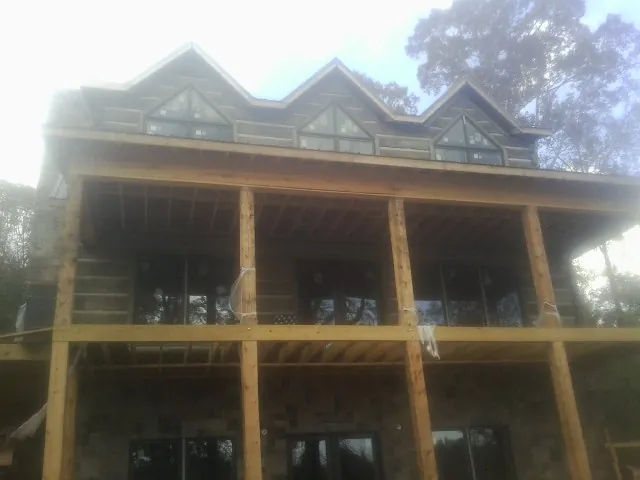Dormers and porch framing on a large log home under construction — Roof Coating work by our crew in Thurmont